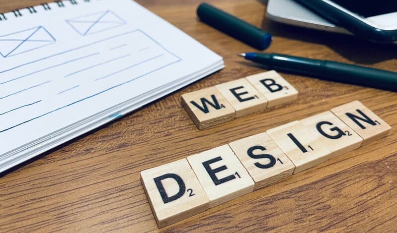 Webdesign mit Scrabble Buchstaben auf einem Schreibtisch